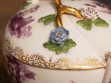 a white and purple bowl with a flower decoration on it