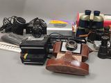 beaucoup de vieux appareils photo et d'autres objets sur la table