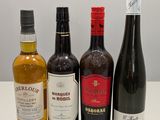 quatre bouteilles de vin sont alignées sur une table