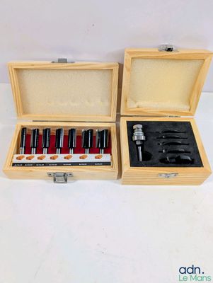 two wooden boxes with tools in them on a white surface