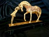 a statue of a horse that is standing on a wooden base