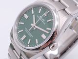 a green watch with roman numerals on the face