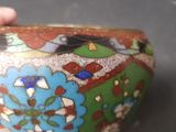 a close up of a hand holding a colorful vase