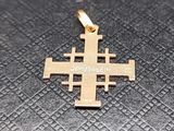gros plan d'une croix en or sur une surface noire