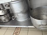 pots and pans sit on a metal shelf in a kitchen