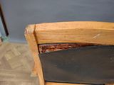 a wooden chair with a black seat and a black seat pad