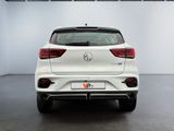 the rear end of a white volkswagen suv parked in a showroom