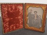 an old photo of a family in a picture frame sitting on a table