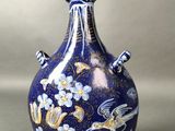 un vase bleu orné d'un motif, posé sur une table