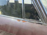 a rusted car that is parked on the side of the road