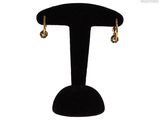 a close up of a pair of earrings on a stand