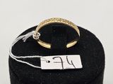 un gros plan d'une bague en or posée sur un présentoir noir