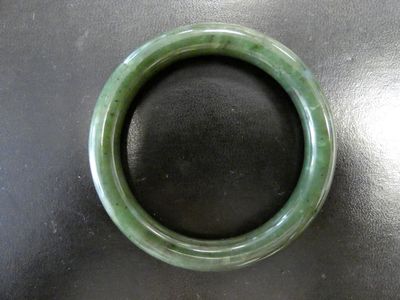 un bracelet vert posé sur une table noire