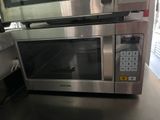 un four à micro-ondes argenté posé sur un plan de travail dans une cuisine