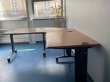 un bureau dans un coin d'une pièce, avec une fenêtre en arrière-plan