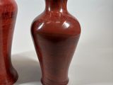 two vases sitting next to each other on a white surface