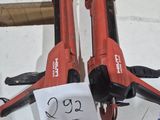 pair of red electric tools sitting on top of a white table