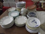 a lot of plates on a table with a red table cloth