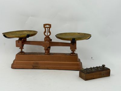 une balance sur laquelle se trouve une boîte, et une autre boîte posée par terre