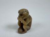 a close up of a figurine of a monkey holding a piece of wood