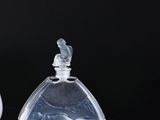 two small glass bottles sitting on top of a black surface
