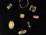 plusieurs bijoux en or et en argent posés sur un fond noir