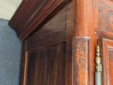 a tall wooden cabinet with a clock on top of it