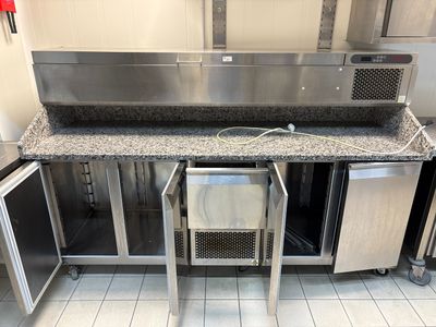 une cuisine équipée d'appareils électroménagers en inox et de plans de travail en granit