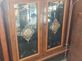 un meuble en bois avec des portes en verre dans une pièce