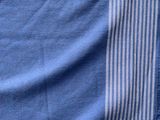 blue and white striped blanket folded on top of a bed