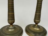 pair of antique brass candlesticks with ornate designs on bases