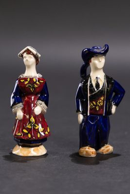 deux figurines représentant des personnes vêtues de costumes traditionnels, debout l'une à côté de l'autre