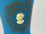 a blue vase with a gold design on it