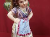 a figurine of a little girl with a basket on her head