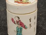 a small container with a painting on it on a table
