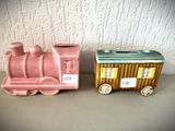 deux petits trains en céramique posés l'un à côté de l'autre sur une table