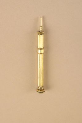 a small brass pipe that is on a beige surface