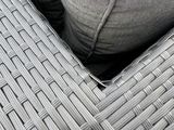 a close up view of a wicker couch with pillows