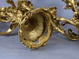 a gold candle holder on a blue surface