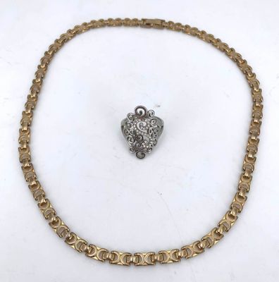 a close up of a gold chain with a heart charm on it