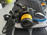 a camera sitting on top of a backpack on a table