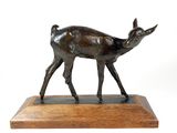 bronze statue of a deer on a wooden base on a white background