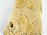 carved ivory plaque with birds and flowers on a white background