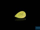 un diamant jaune en forme de poire sur un fond noir