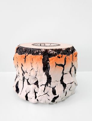 un vase blanc et orange posé sur une surface blanche