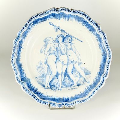 blue and white plate with a painting of a man and a woman on it
