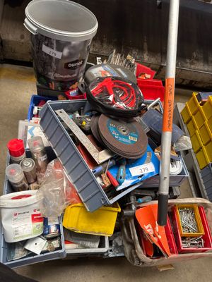 a pile of junk sitting on the ground next to a trash can