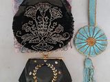 un sac à main noir et un sac à main bleu et doré posés sur une surface blanche