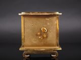 an image of a gold clock sitting on top of a black table