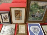 many framed pictures on a red table with a red couch